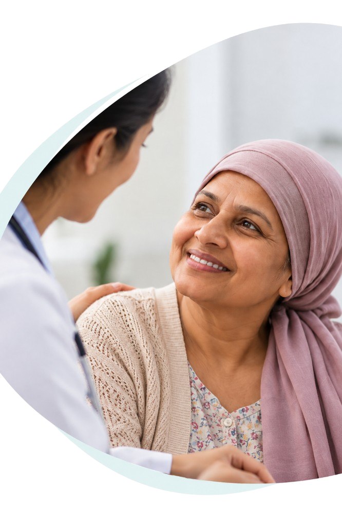 A smiling cancer patient being comforted by her doctor
